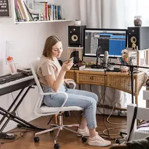 Jugendliche nimmt am Schreibtisch mit Mikrofon und Computer ein YouTube-Video auf
